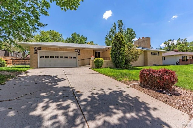 single story home featuring concrete driveway, an attached garage, fence, a front lawn, and brick siding