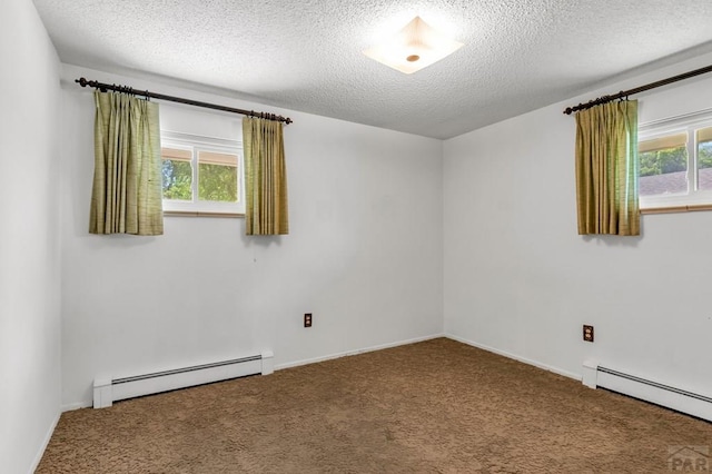 spare room featuring a healthy amount of sunlight, baseboard heating, and carpet flooring