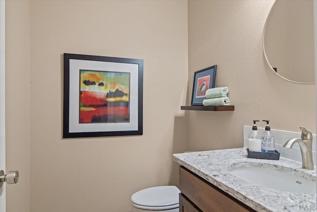 bathroom with toilet and vanity