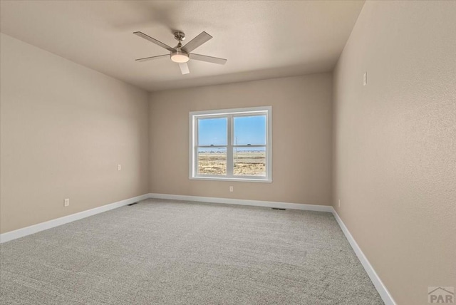 spare room with carpet floors, baseboards, and a ceiling fan