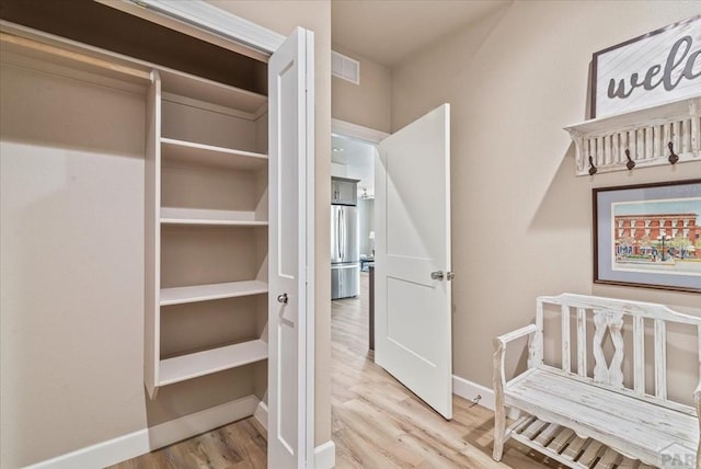 interior space with wood finished floors, visible vents, and baseboards