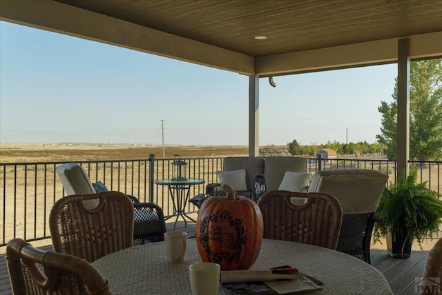 wooden deck featuring outdoor dining area and a rural view