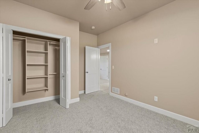 unfurnished bedroom with baseboards, visible vents, a closet, and light colored carpet