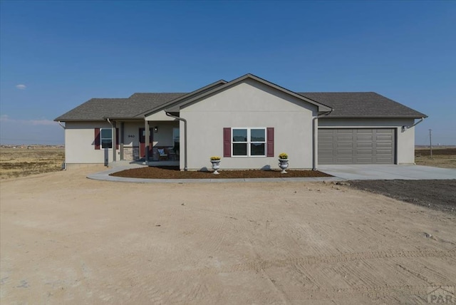 single story home featuring driveway, a shingled roof, an attached garage, a porch, and stucco siding