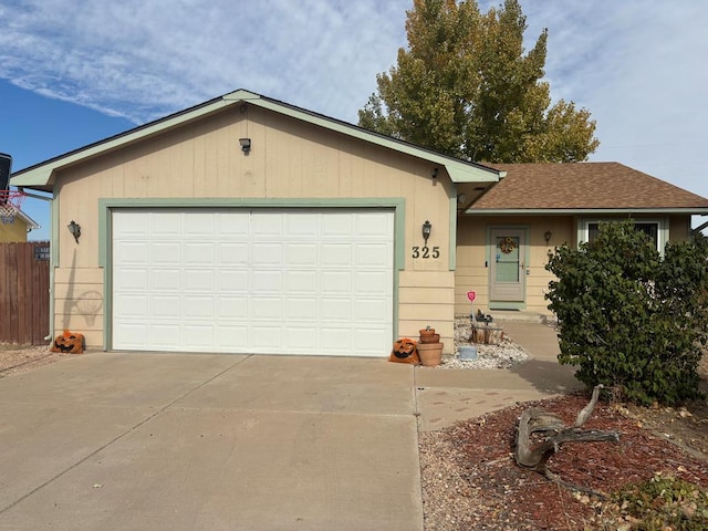 ranch-style home with a garage, driveway, and roof with shingles