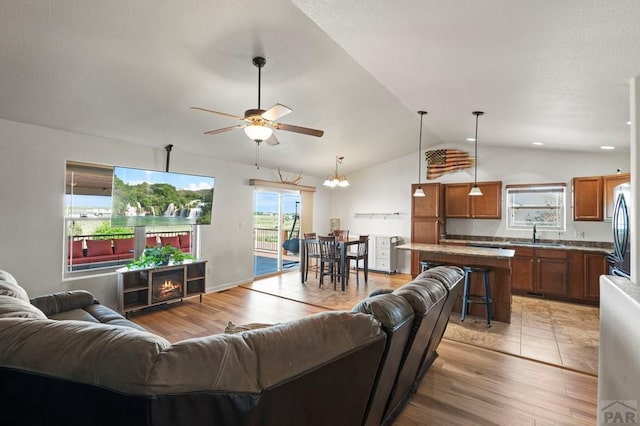 586 N Limon Dr, Pueblo West, CO 81007 - living room featuring a ceiling fan, vaulted ceiling, and light wood-style flooring