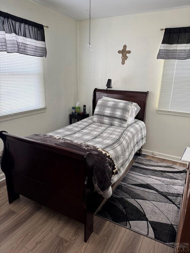 bedroom with baseboards and wood finished floors