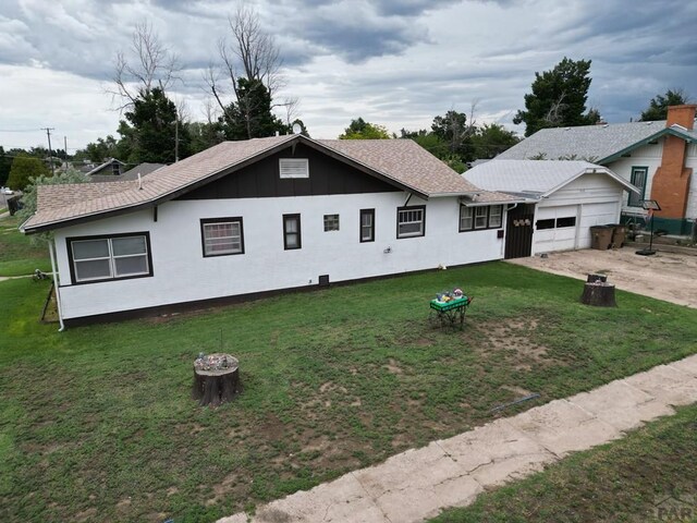 318 W 10th St, La Junta, CO 81050 - view of front of property featuring an attached garage, a front yard, dirt driveway, and board and batten siding
