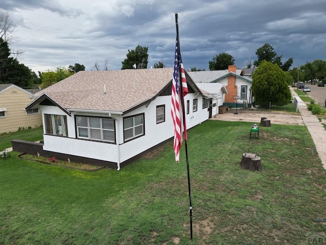 318 W 10th St, La Junta, CO 81050 - view of front facade featuring roof with shingles and a front yard