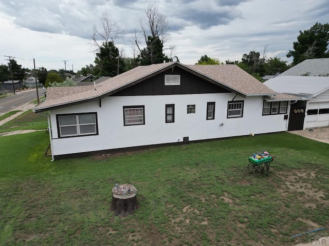 318 W 10th St, La Junta, CO 81050 - view of home's exterior with a yard, an attached garage, and board and batten siding