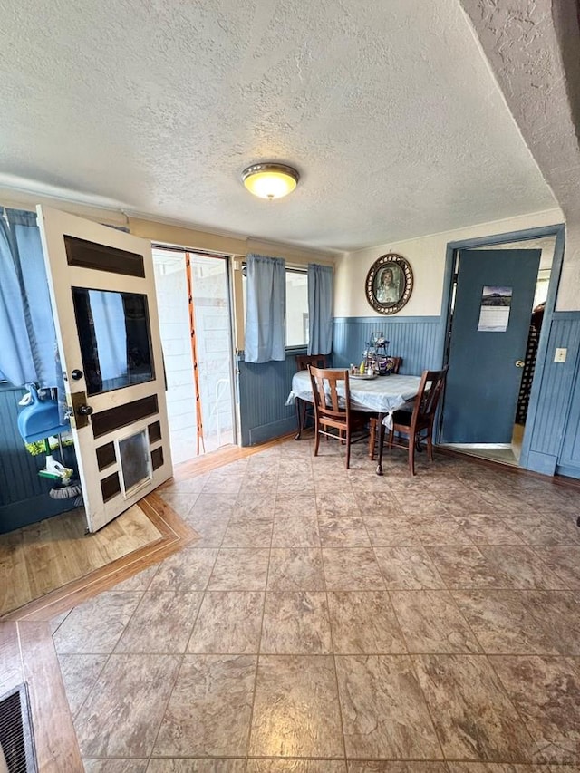 318 W 10th St, La Junta, CO 81050 - dining space featuring wainscoting and a textured ceiling