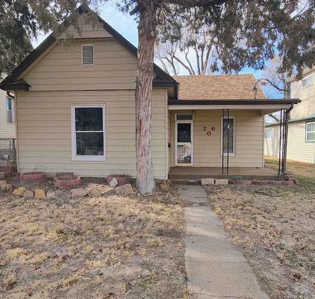 view of front facade with covered porch and roof with shingles