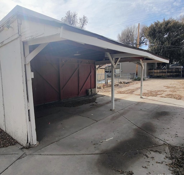 view of parking / parking lot featuring a carport and fence