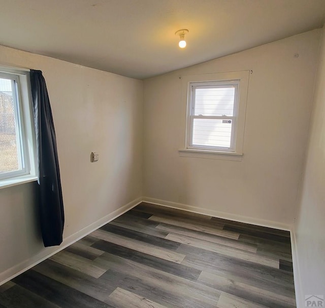 unfurnished room with baseboards, wood finished floors, lofted ceiling, and a healthy amount of sunlight