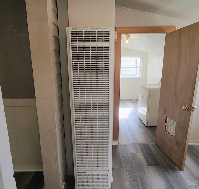 bathroom with wood finished floors, visible vents, vaulted ceiling, washer / clothes dryer, and a heating unit