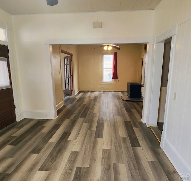 hallway featuring dark wood finished floors and baseboards