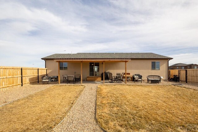 rear view of property with a patio area, a fenced backyard, and stucco siding