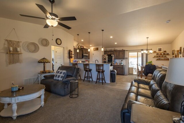 living room featuring lofted ceiling, ceiling fan with notable chandelier, visible vents, and recessed lighting