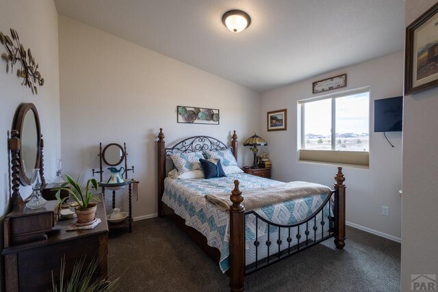 bedroom with dark carpet, vaulted ceiling, and baseboards