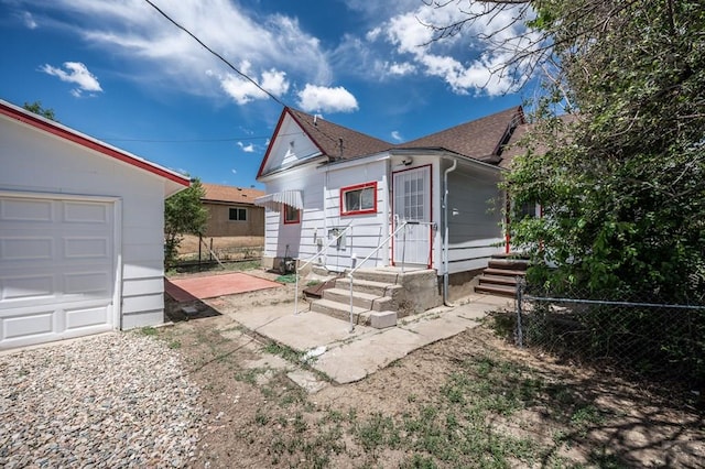320 E Godding, Trinidad, CO 81082 - rear view of house featuring a garage, roof with shingles, and a patio