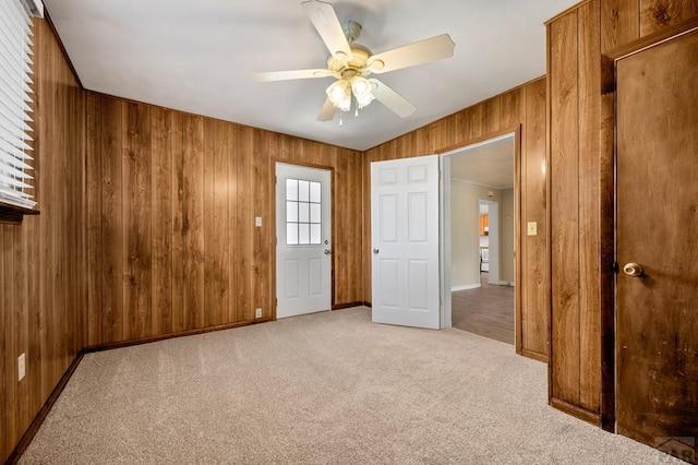 320 E Godding, Trinidad, CO 81082 - unfurnished bedroom with light colored carpet, wood walls, and a ceiling fan