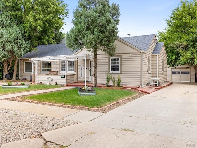 2910 8th Ave, Pueblo, CO 81008 - bungalow-style home with a garage, roof with shingles, an outdoor structure, driveway, and a front yard