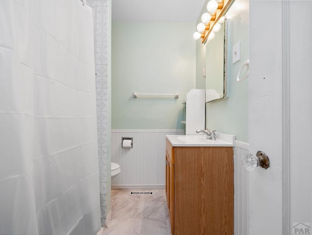 2910 8th Ave, Pueblo, CO 81008 - full bathroom featuring wainscoting, vanity, a shower with curtain, and marble look tile flooring
