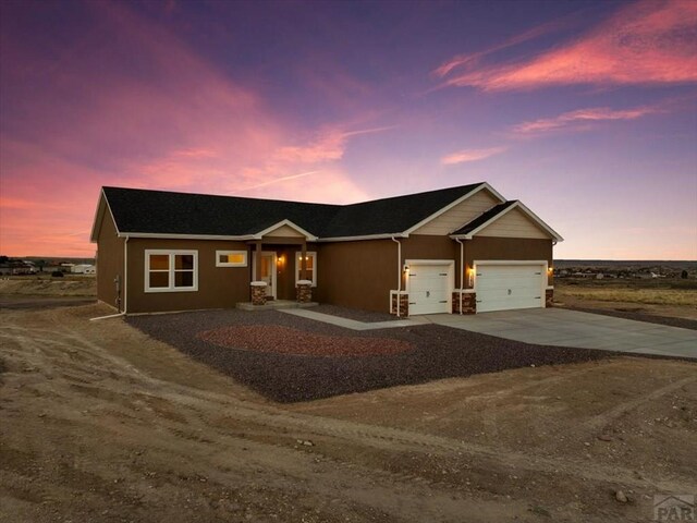 view of front of home featuring concrete driveway, an attached garage, and stucco siding