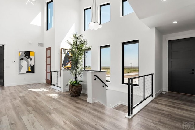 entryway with recessed lighting, baseboards, a high ceiling, and wood finished floors