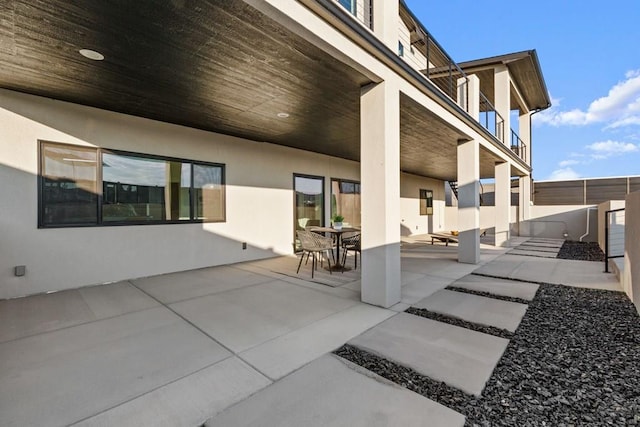 view of patio with outdoor dining space and fence