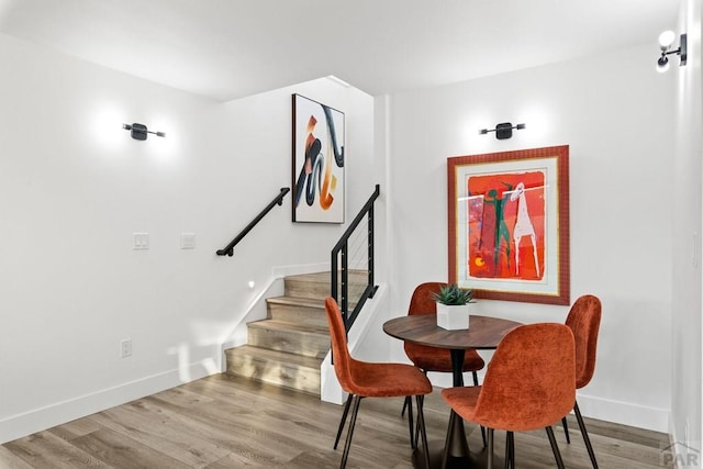 dining area featuring stairway, baseboards, and wood finished floors