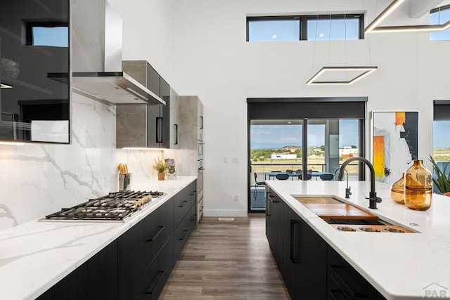 kitchen with modern cabinets, wall chimney range hood, and dark cabinets