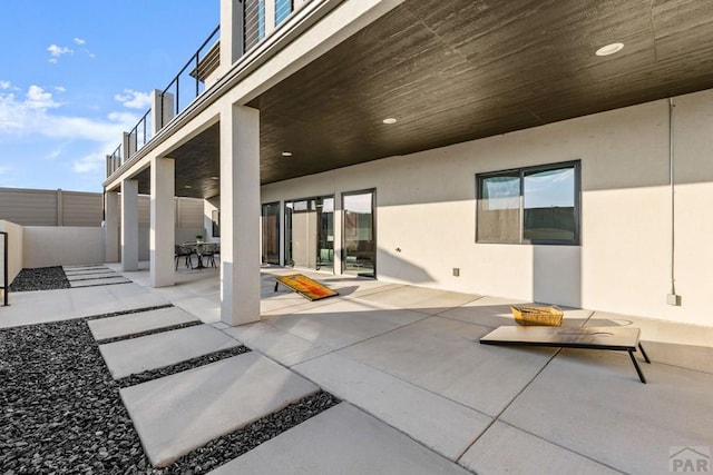 view of patio / terrace with outdoor dining area, a balcony, and fence