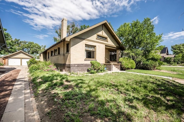 2325 W St, Pueblo, CO 81003 - view of front of home with brick siding, a chimney, an outdoor structure, a detached garage, and a front lawn
