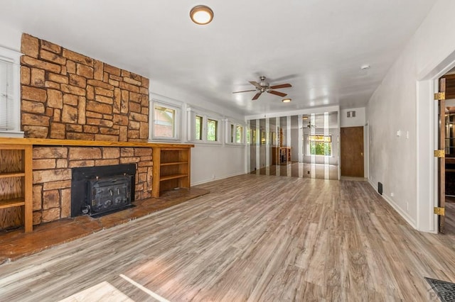 2325 W St, Pueblo, CO 81003 - unfurnished living room featuring ceiling fan, wood finished floors, and a wood stove