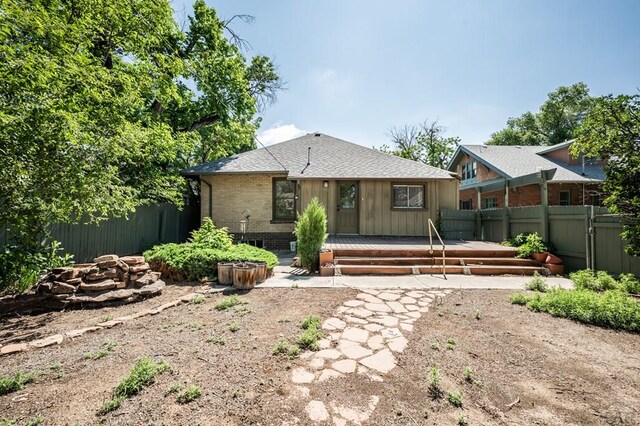 2325 W St, Pueblo, CO 81003 - back of property with a deck, a fenced backyard, roof with shingles, and brick siding