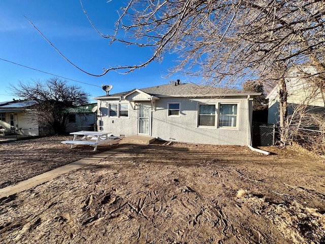 view of front facade featuring fence and stucco siding