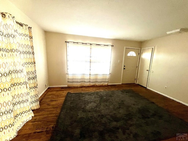 foyer entrance with baseboards and wood finished floors