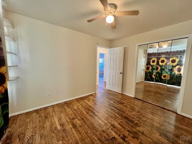 unfurnished room with a ceiling fan, wood finished floors, and baseboards