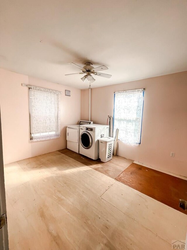 laundry area with light wood-style floors, laundry area, washer and clothes dryer, and a ceiling fan