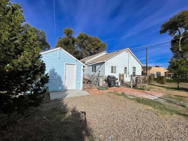 rear view of house with a deck and an outdoor structure