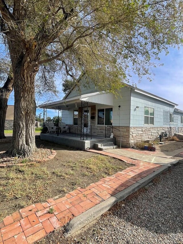 view of front facade featuring stone siding and covered porch