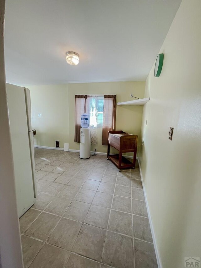 interior space with light tile patterned floors and baseboards