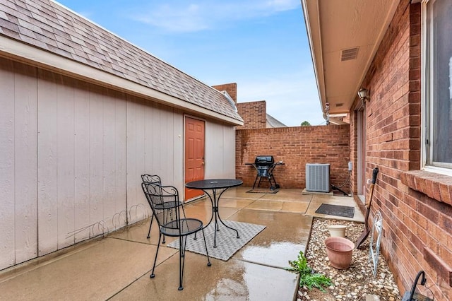 view of patio featuring central air condition unit, fence, and visible vents