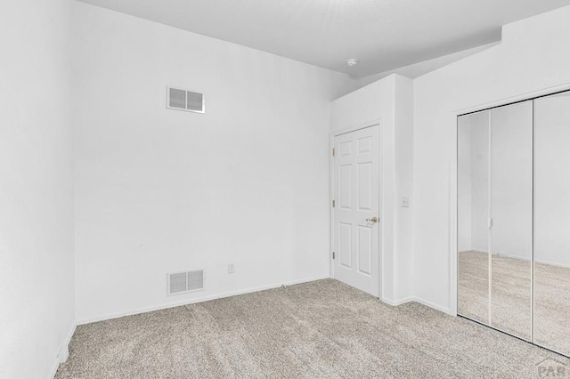 unfurnished bedroom featuring carpet flooring, a closet, and visible vents
