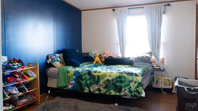 bedroom featuring ornamental molding, dark wood-type flooring, and multiple windows