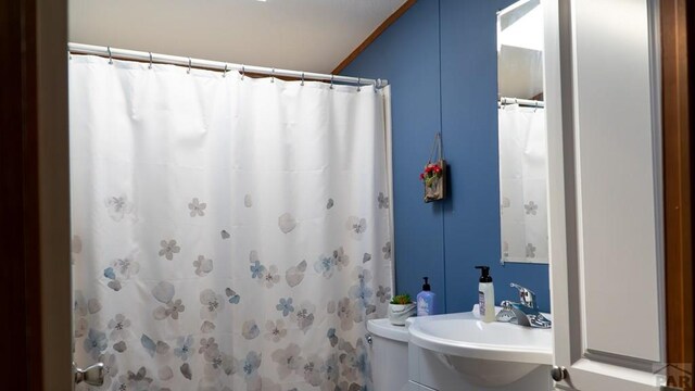 full bath featuring curtained shower and a sink