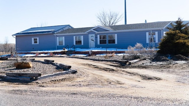 ranch-style home with dirt driveway