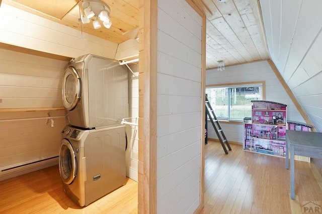 washroom with wooden ceiling, wood walls, stacked washing maching and dryer, light wood-type flooring, and laundry area