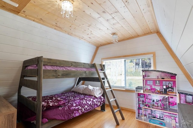 bedroom with wood walls, wood ceiling, vaulted ceiling, and wood finished floors